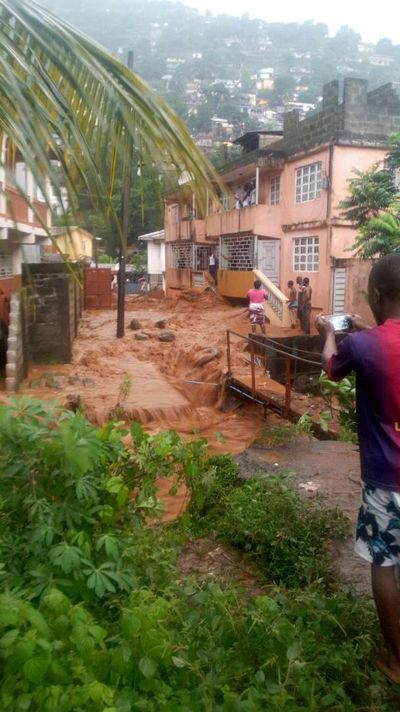 In this image made available by Society 4 Climate Change Communication, Sierra Leone, mud and water cascade near houses in Freetown, Sierra Leone, Monday, Aug. 14, 2017. (Associated Press)