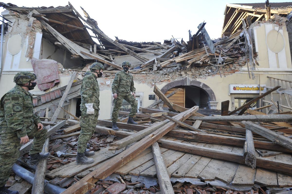 Soldiers inspect the remains of a building damaged in an earthquake, in Petrinja, Croatia, Tuesday, Dec. 29, 2020. A strong earthquake has hit central Croatia and caused major damage and at least one death in a town southeast of the capital.  (STR)