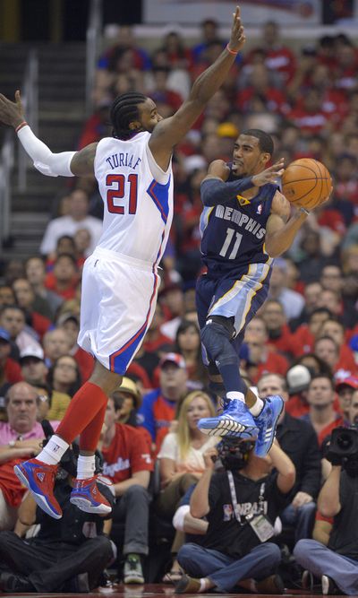 Grizzlies’ Mike Conley, right, shoots around Clippers center Ronny Turiaf on Monday. (Associated Press)