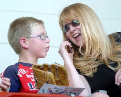 
Cindy Smith enjoys the game with  her son Austin, 9, as she calls  her other sons to gloat.
 (Joe Barrentine / The Spokesman-Review)