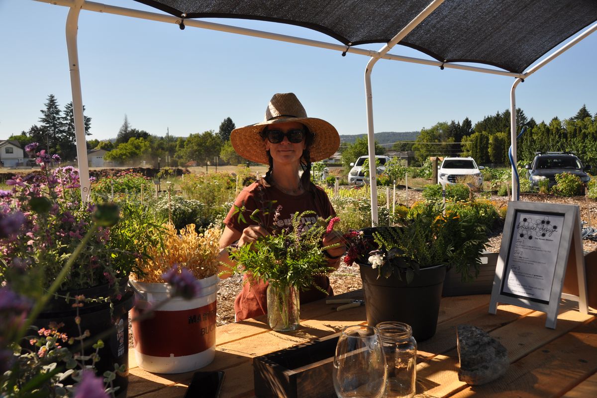 Stacey Martin, a labor and delivery nurse by day, is the community garden’s flower farmer. She is arranging flowers under a cover that will be replaced with a grant from the Spokane Associated Garden Clubs.  (Pat Munts/For The Spokesman-Review)