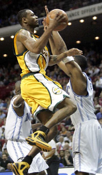 Seattle's Rashard Lewis soars over Orlando's Stacey Augmon on Friday.
(Associated Press / The Spokesman-Review)