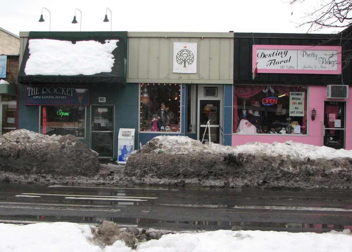 Stores on West Garland Avenue have been surrounded by snow berms.  (Pia Hallenberg / The Spokesman-Review)