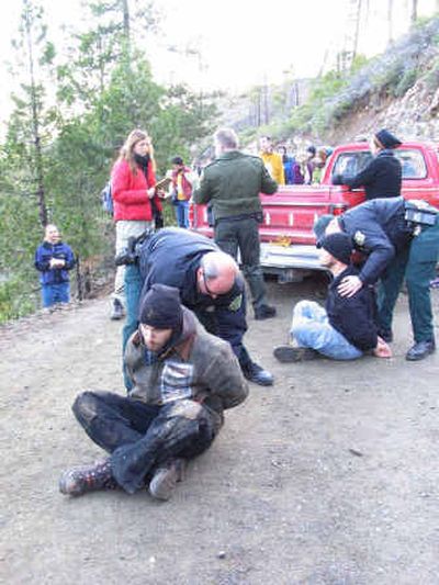 
Law enforcement agents for the U.S. Forest Service handcuff two protesters Monday who were trying to stop loggers from starting to cut trees inside an old growth forest reserve burned by the 2002 Biscuit fire. 
 (Associated Press / The Spokesman-Review)