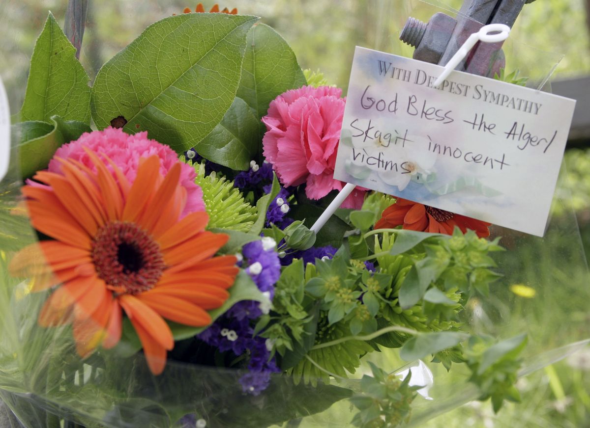 A bouquet of flowers with a card that reads “God Bless the Alger/Skagit innocent victims” was placed near the neighborhood near Alger, Wash., where five of Tuesday’s six killings took place. Associated Press photos (Associated Press photos / The Spokesman-Review)