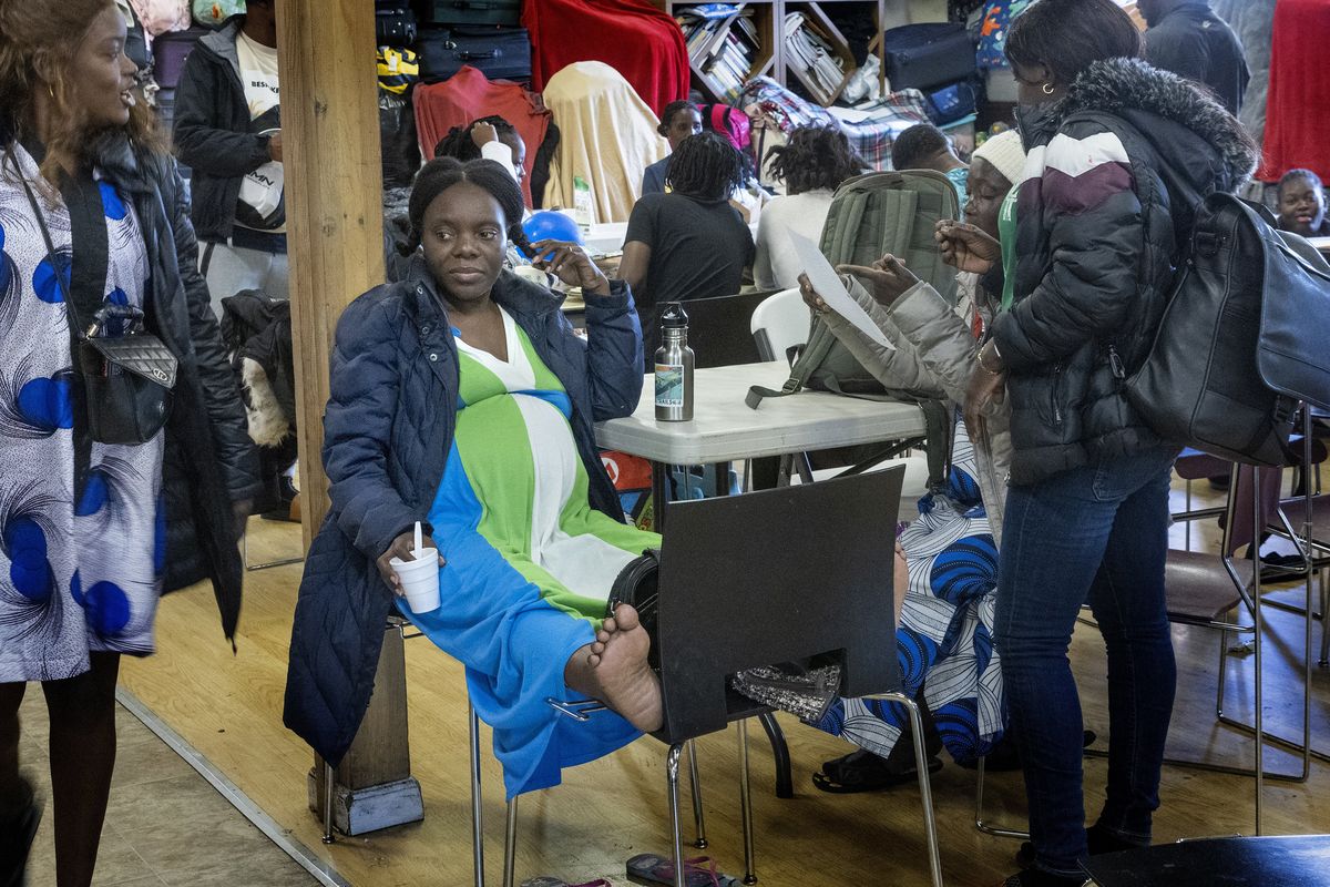 Asylum seeker Lina Ines Zacarias, from Angola, sits in a large room Monday at Riverton Park United Methodist Church in Tukwila. She is due to give birth in two weeks and has two older children who were in school at the time. The family has been in the country for five weeks.  (Ellen M. Banner/The Seattle Times/TNS)