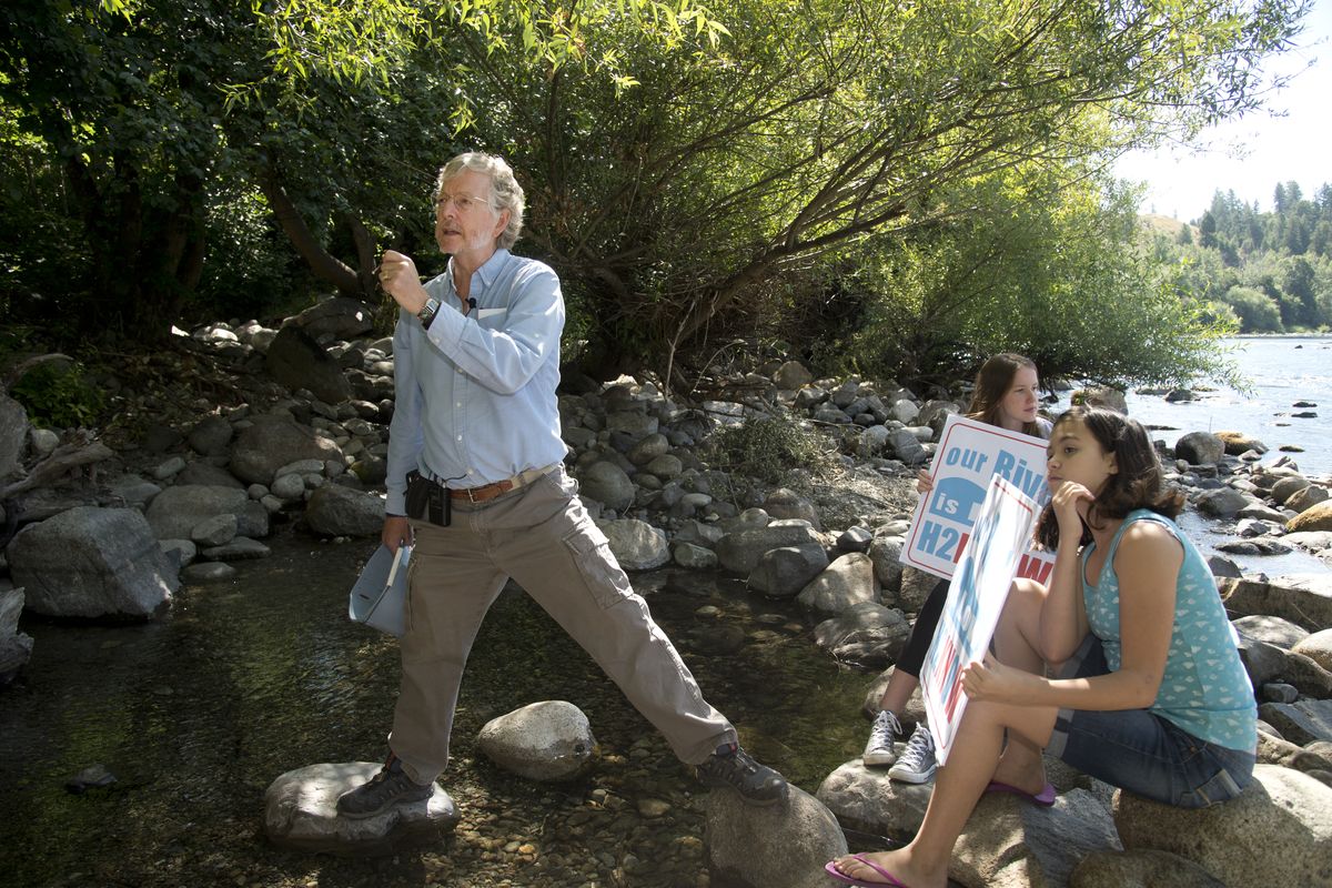 John Osborn, left, talks about conserving water to help the Spokane River during a news conference Wednesday on the river west of downtown. Holding signs are Jora Gleason, 14, and Samarra Salcido, 11. (Jesse Tinsley)
