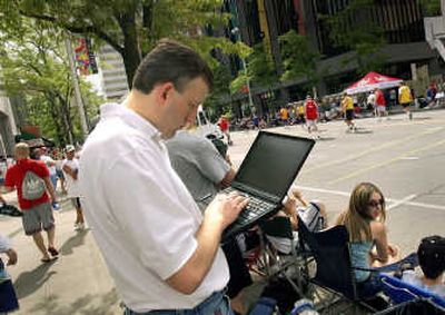 
A Hoopfest fan logs on in the downtown Spokane HotZone wireless area to see how his team is doing in Hoopfest in this file photo.
 (File / The Spokesman-Review)
