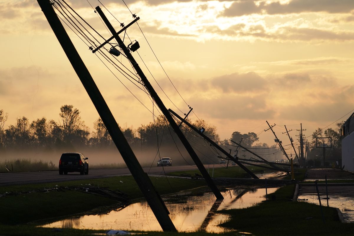 FILE - Downed power lines slump over a road in the aftermath of Hurricane Ida, Friday, Sept. 3, 2021, in Reserve, La. Weather disasters fueled by climate change now roll across the U.S. year-round, battering the nation