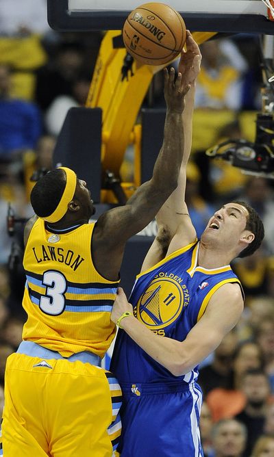 Warriors’ Klay Thompson, right, blocks Ty Lawson’s shot in a 97-95 defeat. (Associated Press)