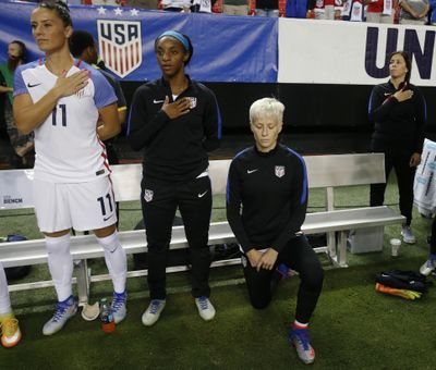 USA’s Megan Rapinoe, right, kneels next to teammates Ali Krieger (11) and Crystal Dunn (16) as the US national anthem is played before an exhibition soccer match against Netherlands, Sunday, Sept. 18, 2016, in Atlanta. (John Bazemore / Associated Press)