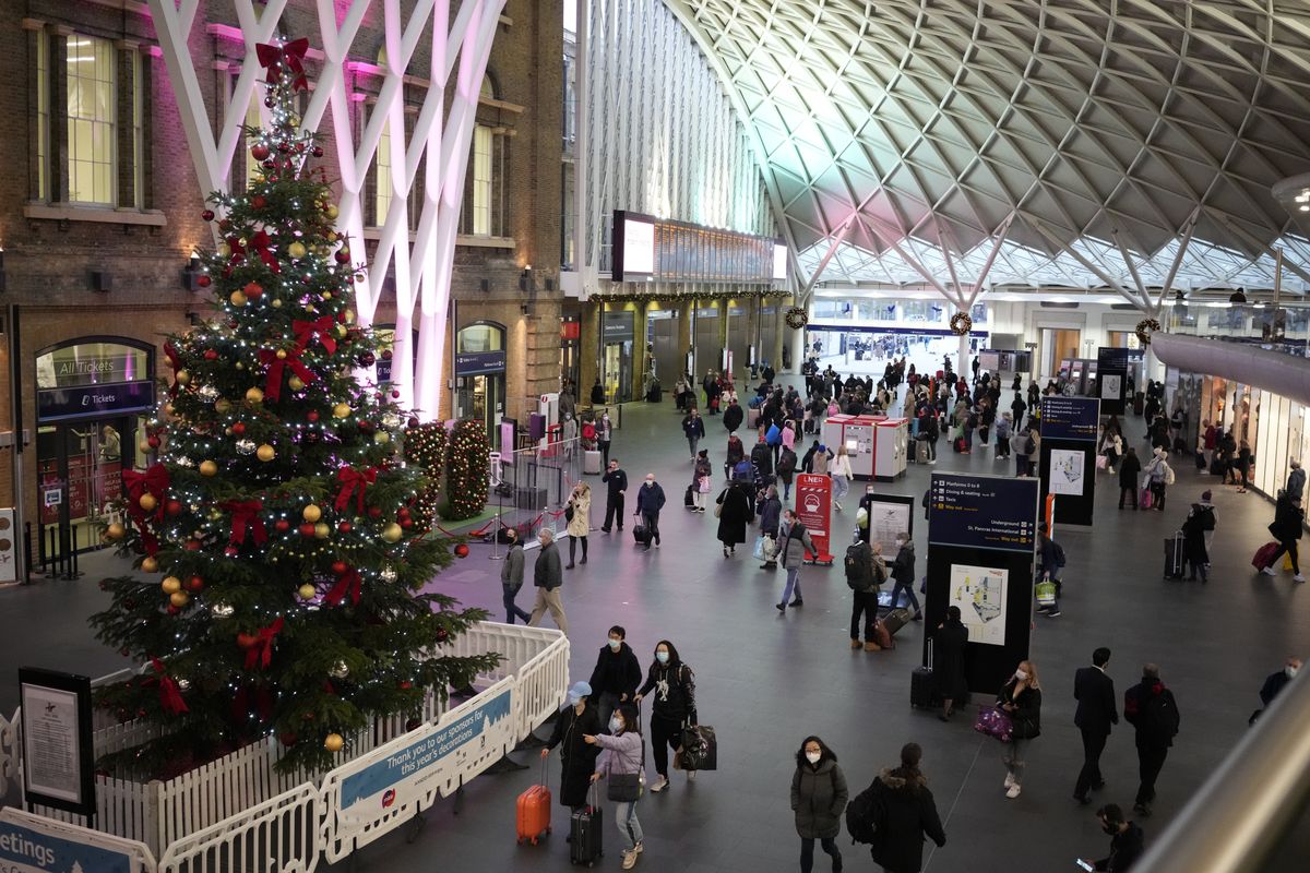 People walk past a Christmas tree in King