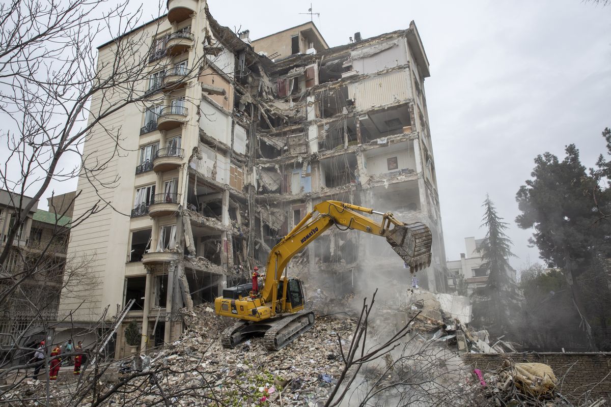 Emergency workers at a residential building that was the site of an airstrike in Tehran, on Monday, March 23, 2026. President Trump said Monday that the United States and Iran were negotiating a "total resolution of our hostilities in the Middle East," and that he would postpone any American attacks on Iranian power plants by five days. (Arash Khamooshi/The New York Times)  (ARASH KHAMOOSHI)