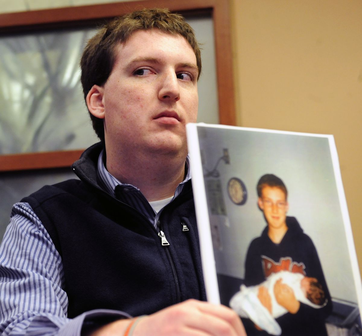 FILE - In this Dec. 8, 2011 file photo, Zach Tomaselli, 23, holds a photo of himself and his brother taken at about the time he claims he was was sexually abused in 2002 by former Syracuse basketball coach Bernie Fine, at a news conference in Pittsburgh. Federal authorities have dropped their investigation into sexual abuse claims that cost Fine his job, threw a top-ranked team into turmoil and threatened the career of Hall of Fame coach Jim Boeheim. After a probe spanning nearly a year, U.S. Attorney Richard Hartunian said Friday, Nov. 9, 2012 there was no evidence to support claims that Fine had molested a boy in 2002 in a Pittsburgh hotel room. The investigation erupted in the glare of a spotlight on child abuse shone by the Penn State University scandal that broke shortly beforehand, when Davis and Lang accused the longtime assistant of fondling them when they were teens. (John Heller / Fr48174 Ap)