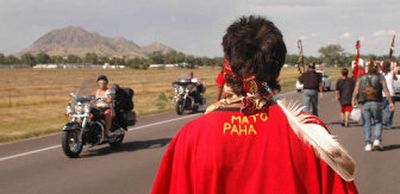 Cante Ohitika Martin, of Kiza Park, S.D., displays the Oglala Lakota tribe words for Bear Butte on the back of his shirt as he and others march to Bear Butte on Friday near Sturgis, S.D.
(Associated Press / The Spokesman-Review)