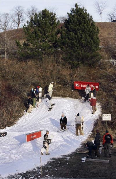 
Teenage snowboard riders and skiers take advantage of a 15-foot vertical drop of artificial snow that was trucked to a small hill Thursday in Portland, Maine. The Sunday River ski resort in Newry, Maine, brought the snow to the city to let people know there is still skiing. 
 (Associated Press / The Spokesman-Review)