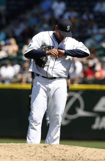 Felix Hernandez looks at his wrist after being hit by a ball. (Associated Press)