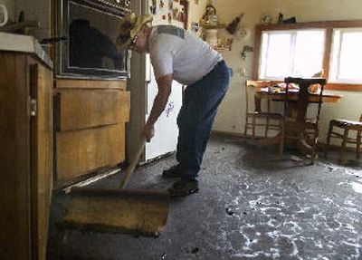 
Dennis McClellan shovels mud out of his friend Charles Layton's kitchen on Monday in Spangle. 
 (Colin Mulvany / The Spokesman-Review)