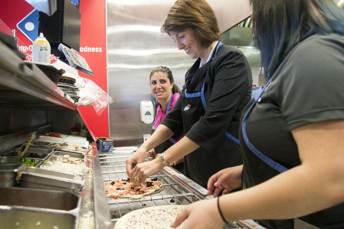 U.S. Rep. Cathy McMorris Rodgers, center, learns to make a pizza from Domino’s Pizza Legislative Affairs Manager Ashley Coneff, left, and Domino’s area manager Sarah Anderson, right, Thursday, Nov. 12, 2015 at a Dominos Pizza restaurant in Spokane Valley. McMorris Rodgers, who is sponsoring a House bill to allow pizza chains like Domino’s to put nutrition information on the internet, talked with owners and employees at the Domino’s franchise Thursday. (Jesse Tinsley / The Spokesman-Review)