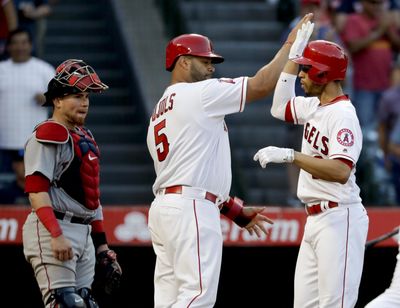 Los Angeles Angels’ Andrelton Simmons, right, celebrates his two-run home run with Albert Pujols  during the third inning  Saturday in Anaheim, California. (Chris Carlson / Associated Press)