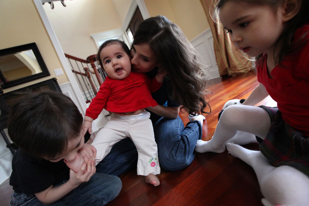Mariana Patzelt, center, plays with her children, from left: Benjamin Hale, 5, Olivia Hale, 6-months, and Amelia Hale, 3, at their home in Old Norwood, Ill. Patzelt, 27, had two C-sections before having a successful vaginal birth after a cesarean, or VBAC.