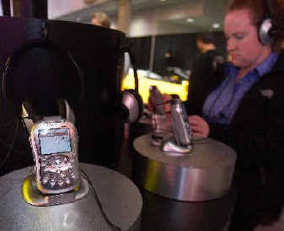 
A woman listens to a Delphi portable satellite radio receiver on display at the XM booth Wednesday at the Consumer Electronics Show in Las Vegas.
 (Associated Press photos / The Spokesman-Review)