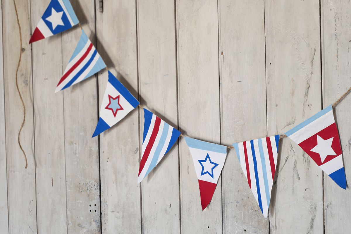 Stars and Stripes Bunting, adapted from Amanda Kingloff’s book “Project Kid,” uses fabric or paper, freezer paper and acrylic paint. (Associated Press)