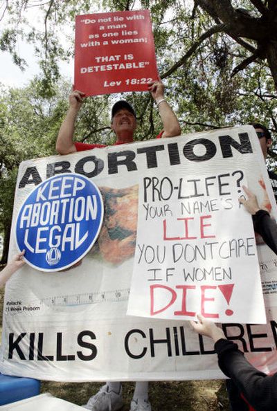 
Anti-abortion activist Kenneth Scott, of Denver, has his sign partially blocked Saturday during a rally in Jackson, Miss. Both sides proclaim the state as the new Roe v. Wade battleground. 
 (Associated Press / The Spokesman-Review)
