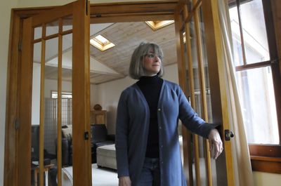 Merry Armstrong stands between a pair of French doors installed by a contractor she hired to make improvements to her 1929 home. The contractor remodeled a Jacuzzi room into the den behind her and helped her oversee work by other contractors.  (Jesse Tinsley / The Spokesman-Review)