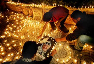 
Palestinians light candles at a makeshift shrine in support of Palestinian leader Yasser Arafat in Gaza City on Tuesday. Arafat is in a coma, a spokesman said.Palestinians light candles at a makeshift shrine in support of Palestinian leader Yasser Arafat in Gaza City on Tuesday. Arafat is in a coma, a spokesman said.
 (Associated PressAssociated Press / The Spokesman-Review)