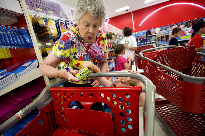 Julie Wilkins helps her grandson, Griffin Brady, 3, put a box of crayons in a shopping cart while shopping for school supplies at a Target store in Memphis, Tenn., in July. (Associated Press)