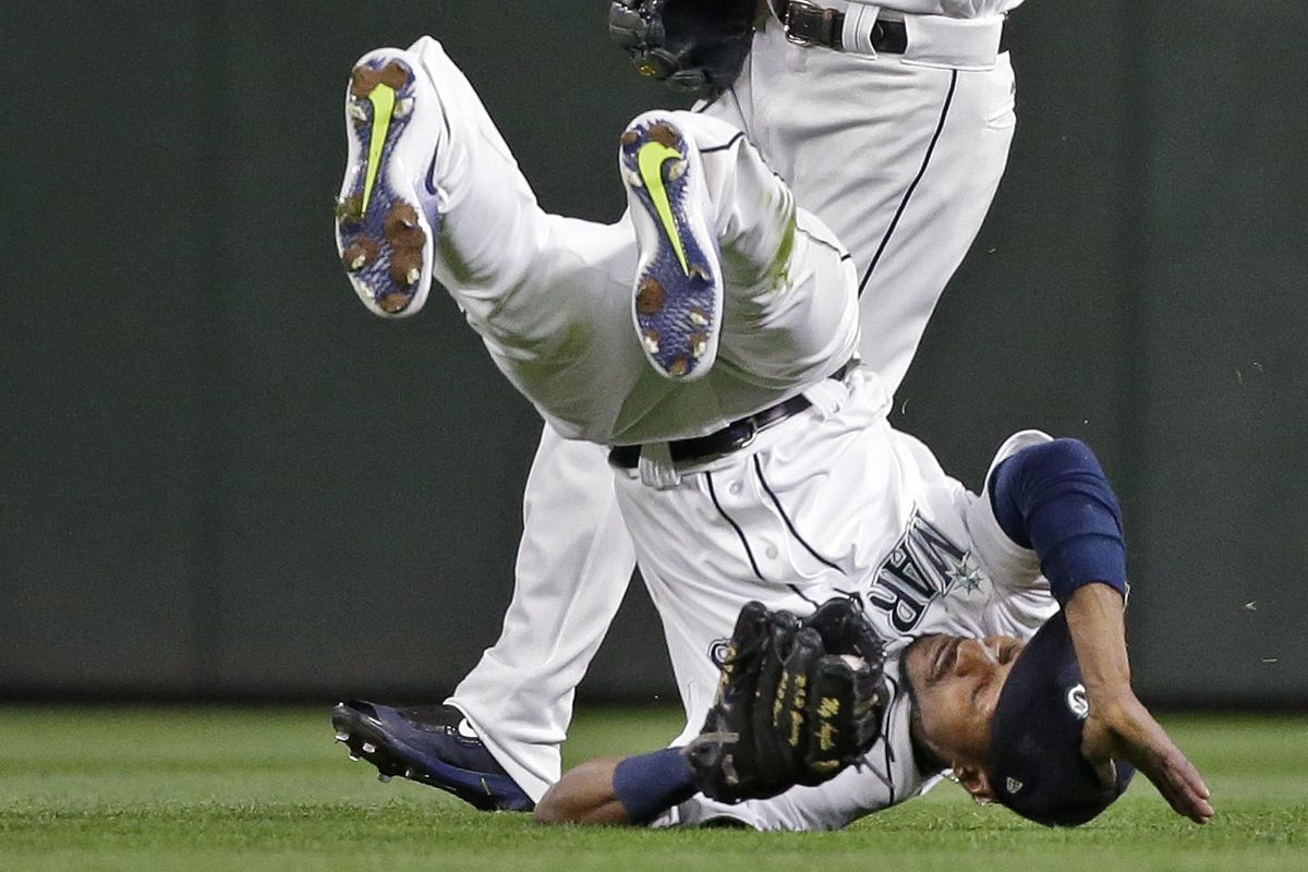 Seattle Mariners center fielder Jarrod Dyson tumbles after snagging a fly ball from Oakland Athletics’ Khris Davis in the sixth inning of a baseball game Monday, May 15, 2017, in Seattle. (Elaine Thompson / Associated Press)