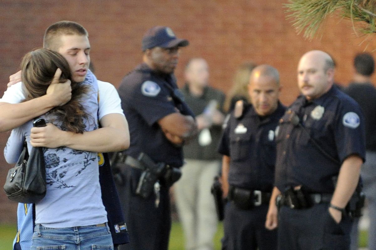 Eyewitness Jacob Stevens, 18, hugs his mother, Tammi Stevens, after being interviewed by police outside Gateway High School, where shooting witnesses were brought for questioning Friday in Aurora, Colo. Stevens was in the theater when James Holmes allegedly opened fire on people watching “The Dark Knight Rises.” (Associated Press)