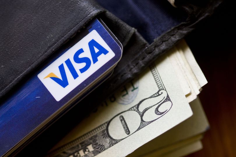 In this file photo taken Feb. 2, 2011, a wallet containing cash and a Visa card is displayed in Surfside, Fla. (Wilfredo Lee / Associated Press)