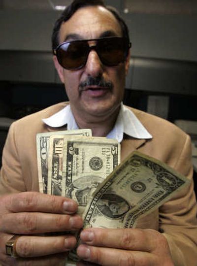 
Mitch Pomerantz holds U.S. currency he can't differentiate. Associated Press
 (Associated Press / The Spokesman-Review)