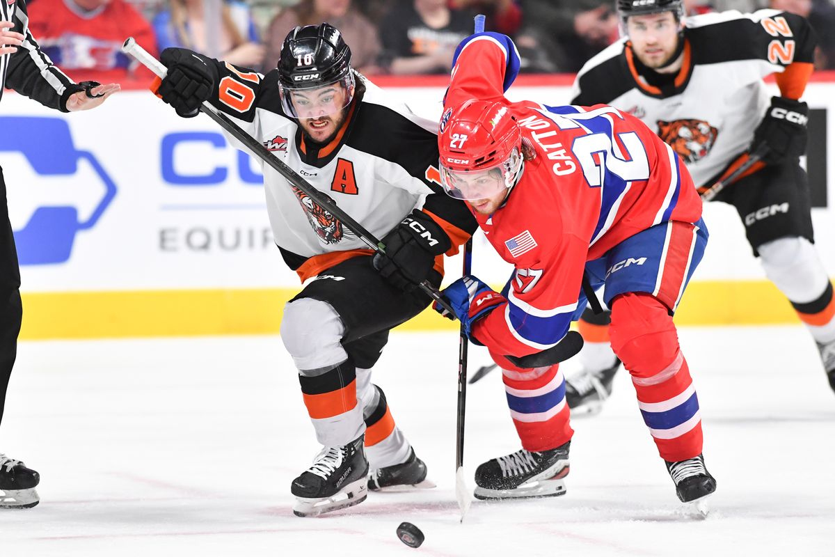 Spokane center Berkly Catton vies for control of the puck against Medicine Hat center Mathew Ward during the the WHL Championship on May. 14 at the Arena.  (TYLER TJOMSLAND)