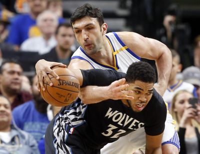 Golden State Warriors’ Zaza Pachulia, top, slows down Minnesota Timberwolves’ Karl-Anthony Towns during the second half of an NBA basketball game Friday, March 10, 2017, in Minneapolis. (Jim Mone / Associated Press)