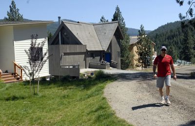 Michael Rogers walks up Liberty Creek Lane from his house (third from left) in Liberty Lake. Spokane County halted the work on the house  due to an overheight violation. The  house is 7 feet over a 35-foot limit in the rural conservation area. (J. BART RAYNIAK / The Spokesman-Review)