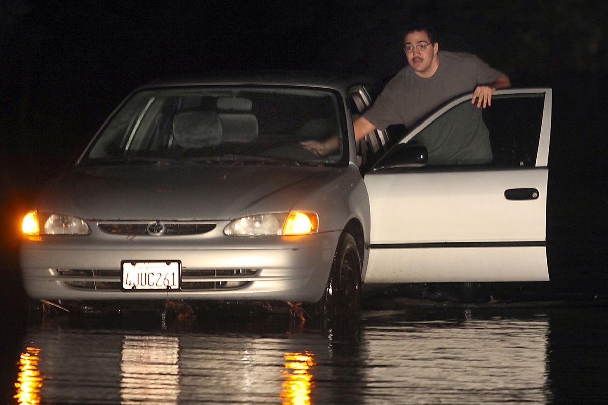 Robert St. Andre  pushes his flooded vehicle out of the water at Rohnert Park Expressway and Stony Point Road, Friday Nov. 30, 2012, in Rohnert Park, Calif. The second in a series of storms slammed Northern California on Friday as heavy rain and strong winds knocked out power, tied up traffic and caused flooding along some stretches. (Kent Porter / The Press Democrat)
