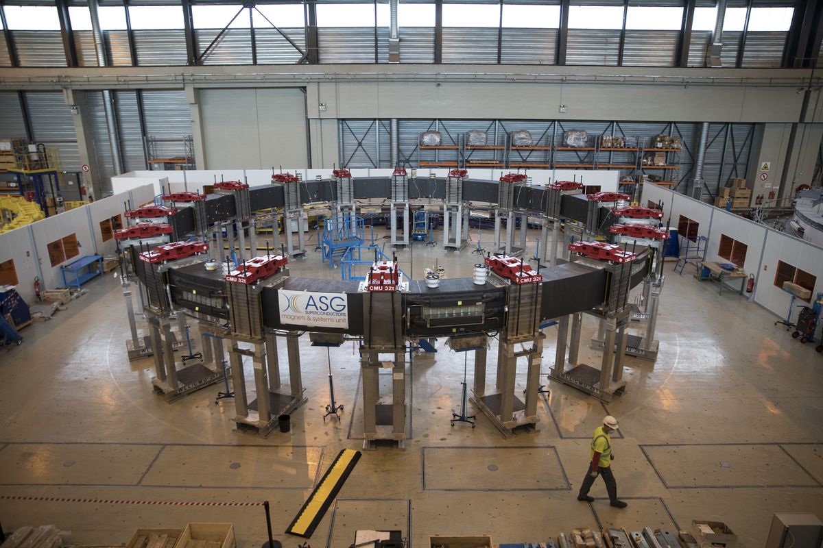 A worker walks by the ITER poloidal field coil #5 designed to shape plasma and meant for the assembly of the ITER Tokamak in Saint-Paul-Lez-Durance, southern France,, Tuesday, July 28, 2020. A project of daunting proportions and giant ambitions replicating the energy of the sun is entering a critical phase as scientists and technicians begin piecing together massive parts built around the globe of a nuclear fusion device, an experiment aimed at showing that clean energy, free of carbon emissions, can keep our planet humming.  (Daniel Cole)