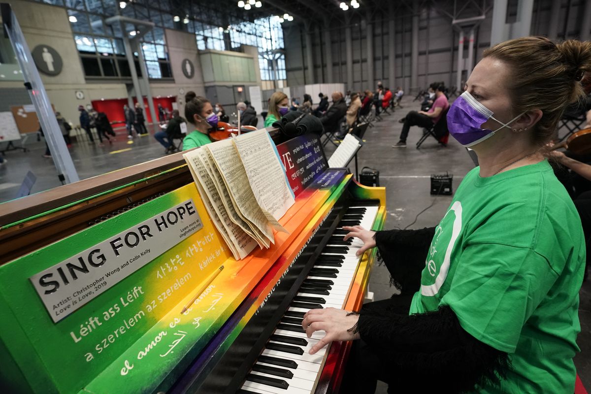 Pianist and CUNY music professor Barbara Podgurski plays with a string quartet for people who had received a COVID-19 vaccination and were waiting during the observation period, at the Jacob K. Javits Convention Center, Thursday, March 18, 2021, in New York. The convention center, which early in the pandemic served as a temporary field hospital, has been converted into a massive vaccination site.  (Kathy Willens)