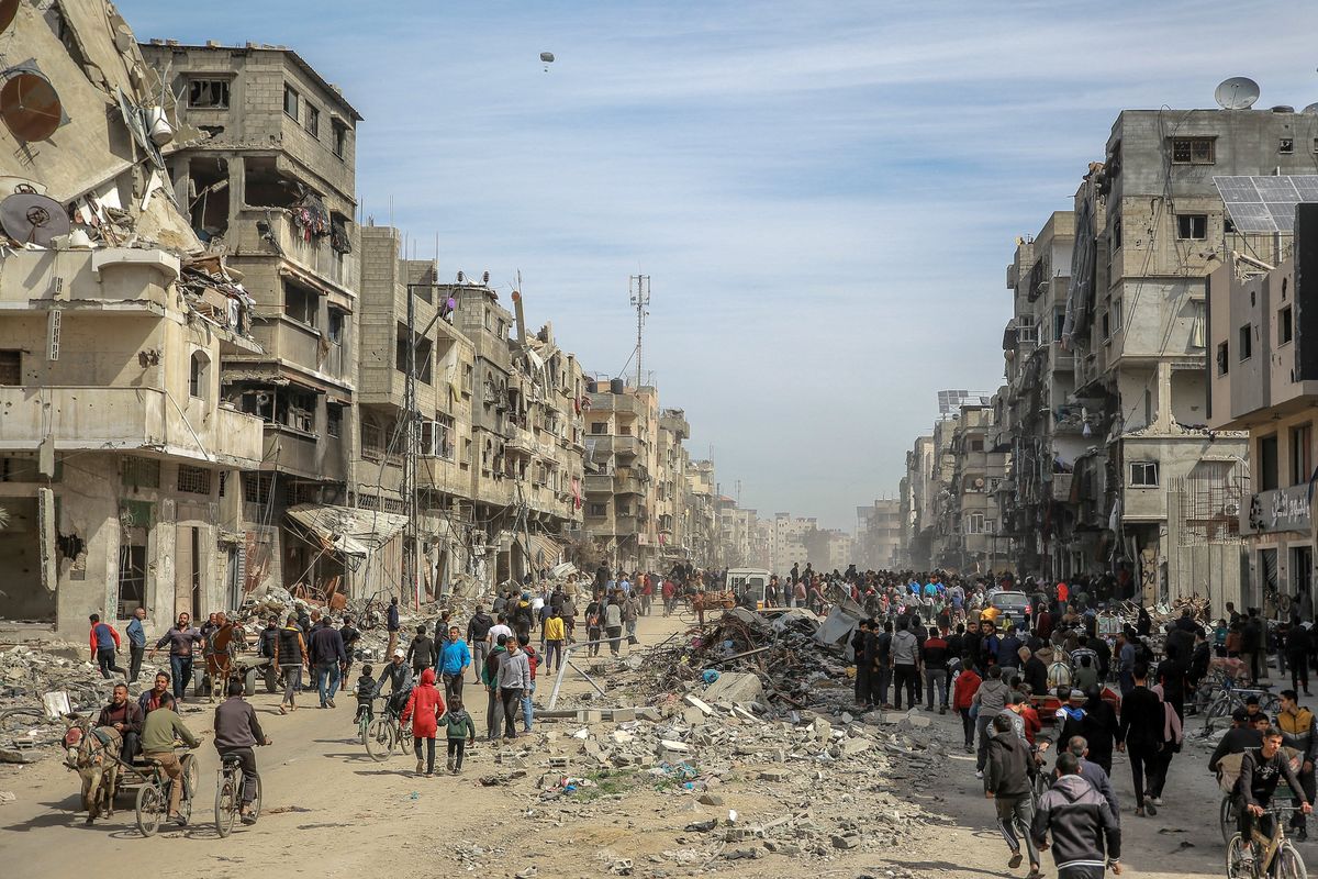 Palestinians gather in a street as humanitarian aid is airdropped in Gaza City on Friday amid the ongoing conflict between Israel and the Hamas militant group.  (AFP)