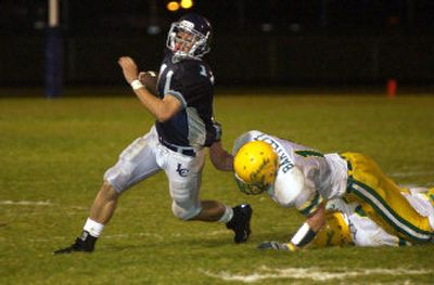 
Lakeland's Bubba Bartlett gets a handful of Lake City's Chris Delport Friday night at Lake City High School. 
 (Tom Davenport/ / The Spokesman-Review)