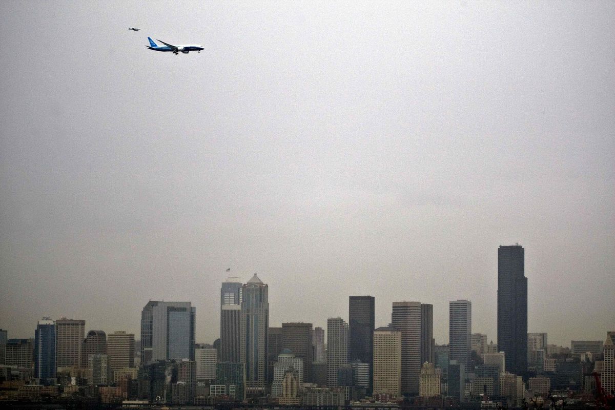 A chase plane is dwarfed beside Boeing’s 787 on the Dreamliner’s maiden flight Tuesday over Seattle.  Associated Press/Dean Rutz, Seattle Times (Associated Press/Dean Rutz, Seattle Times)