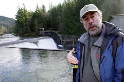 
U.S. Forest Service hydrologist Gordon Grant poses at the Marmot Dam on the Sandy River in November 2005 near Sandy, Ore. A century ago, the Bull Run Hydroelectric Project, including Marmot Dam, was a marvel of modern engineering, moving water diverted by dams on two rivers through miles of wooden flumes, canals and a tunnel to produce some of the first electricity to light Portland. But Portland General Electric has decided that the project is no longer economical to run. 
 (Associated Press / The Spokesman-Review)