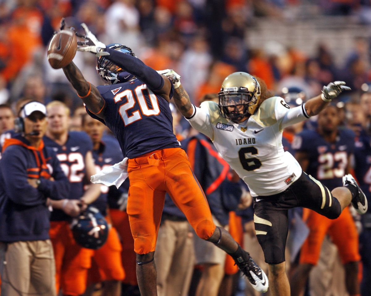 Virginia’s Tim Smith just misses a reception as Idaho’s Aaron Grymes defends during Saturday’s game. (Associated Press)