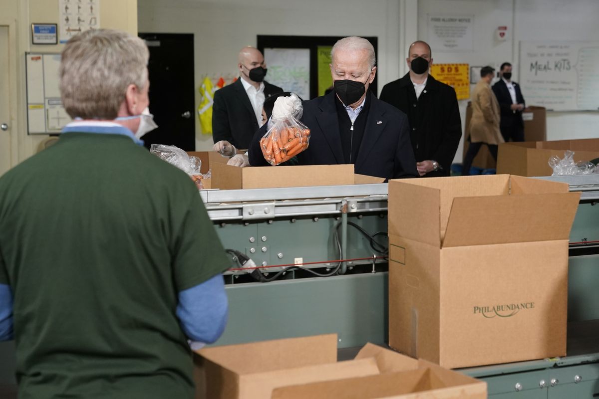 President Joe Biden packs produce while volunteering at hunger relief organization Philabundance, Sunday, Jan. 16, 2022, in Philadelphia.  (Patrick Semansky)