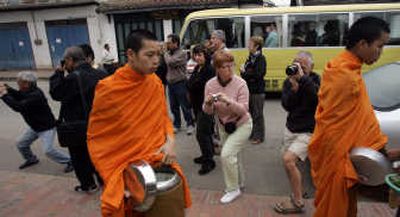 Western and Asian tourists alike jockey for position to photograph Buddhist monks in Luang Prabang, Laos. Once a French colonial outpost, Luang Prabang today has become a favorite stop on the backpacker circuit. Associated Press
(Associated Press / The Spokesman-Review)