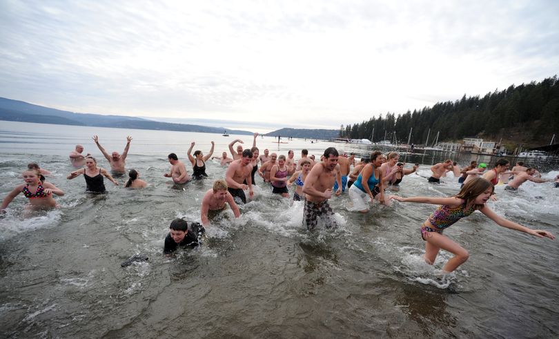 Plungers young and old dash out of, as quickly as they rushed into, the chilly waters of Lake Coeur d'Alene Sunday, Jan. 1, 2011 during the annual Polar Bear Plunge at Sanders Beach.  The informally organized event started with a few friends making the jump to more than 1000 people crowding the beach to swim or to watch. (Jesse Tinsley / The Spokesman-Review)