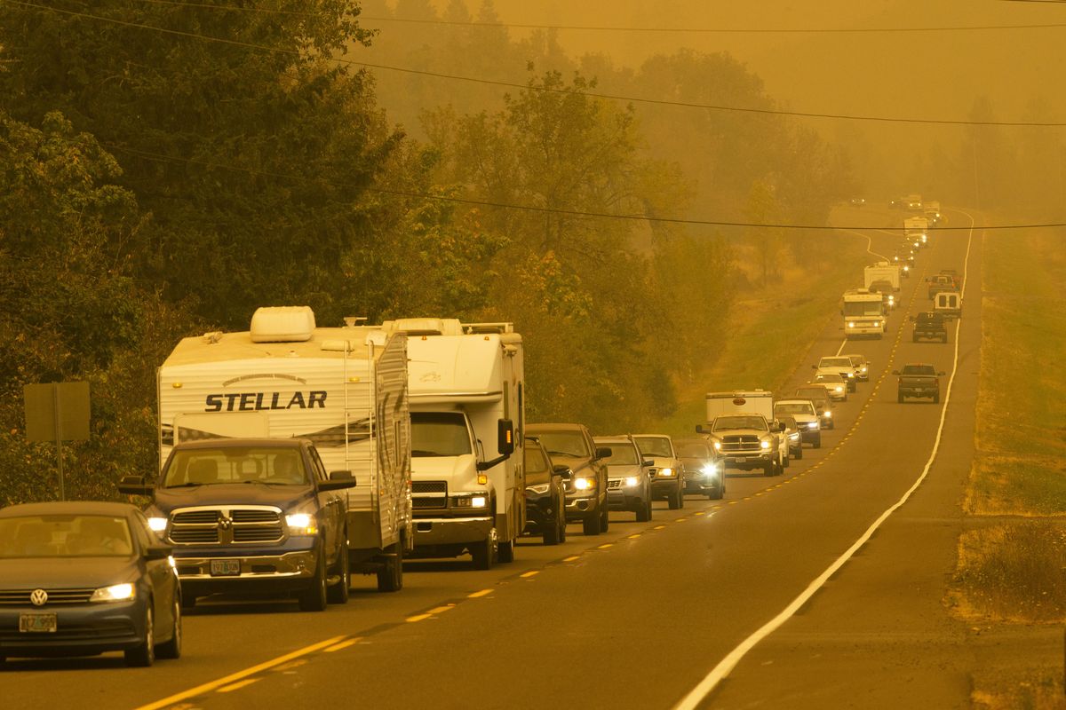 A steady stream of vehicles heads west on a road east of Springfield, Ore., as residents evacuate the area ahead of a fast-moving wildfire on Tuesday.  (Associated Press)
